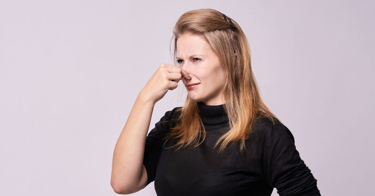 Woman pinching nose to not smell a bad odor