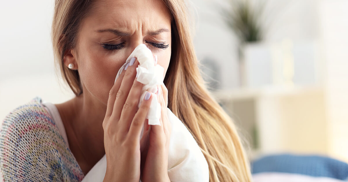 woman sneezing because of mold