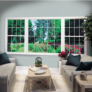 Photo of interior of living room showing picture window and two double hung windows with grids