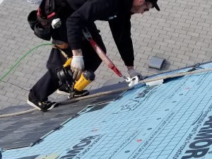 man installing new roofing