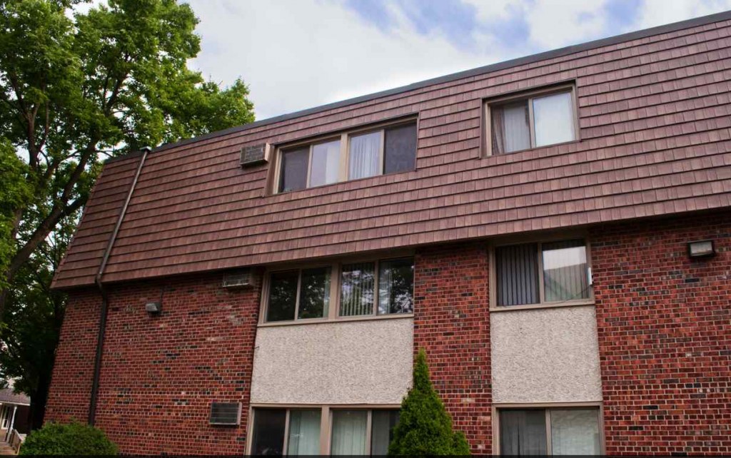 Exterior of brick apartment complex showing KasselWood steel roofing on mansard roof
