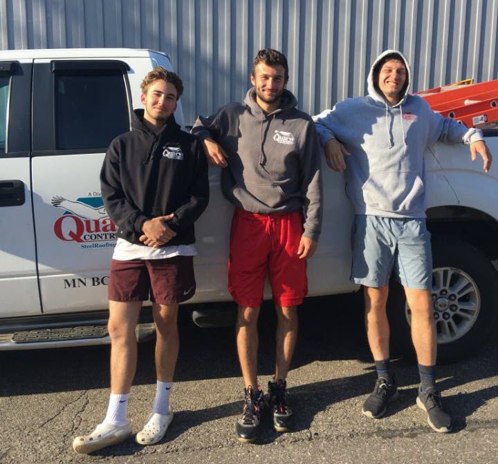 3 young men beside construction truck