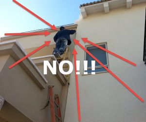 Man high up on ladder working on gutters