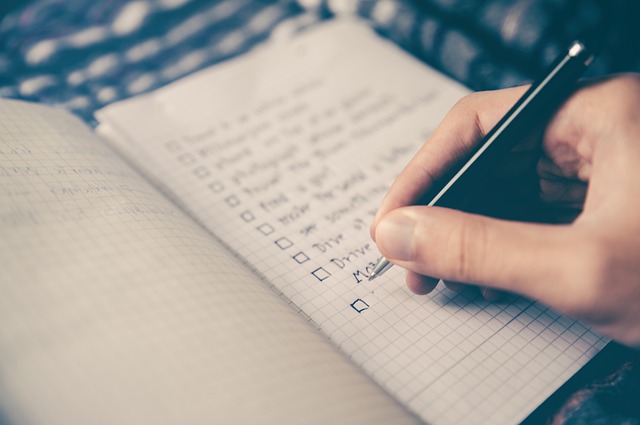 Man checking off items on list in notebook