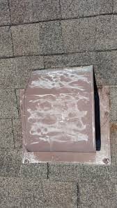 Closeup of hail-damaged roof vent on asphalt roof